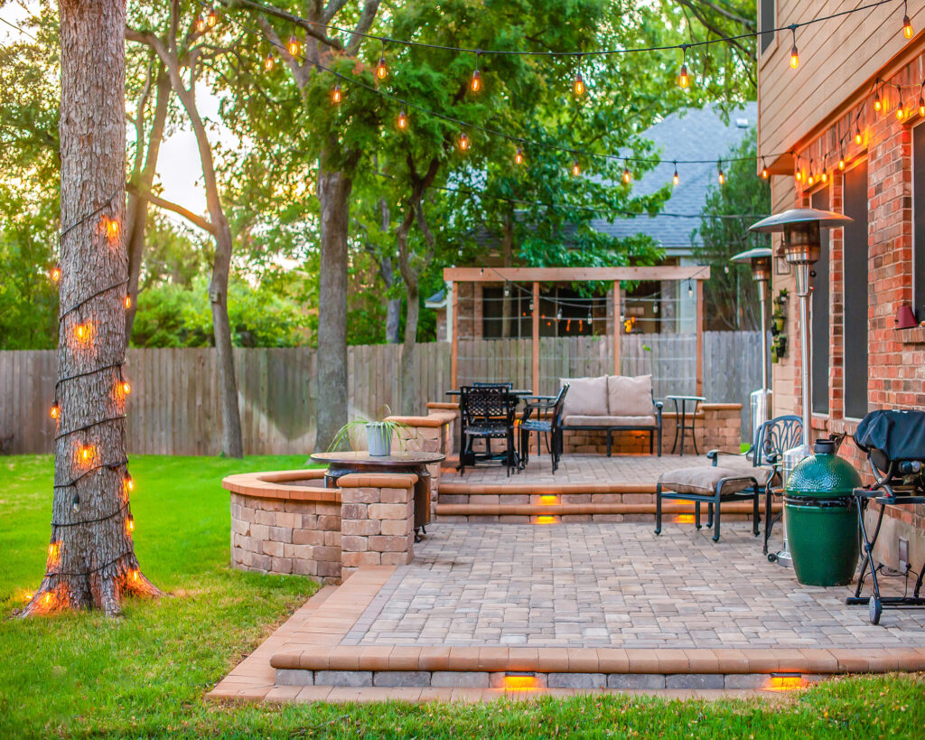 Cozy backyard brick patio with string lights